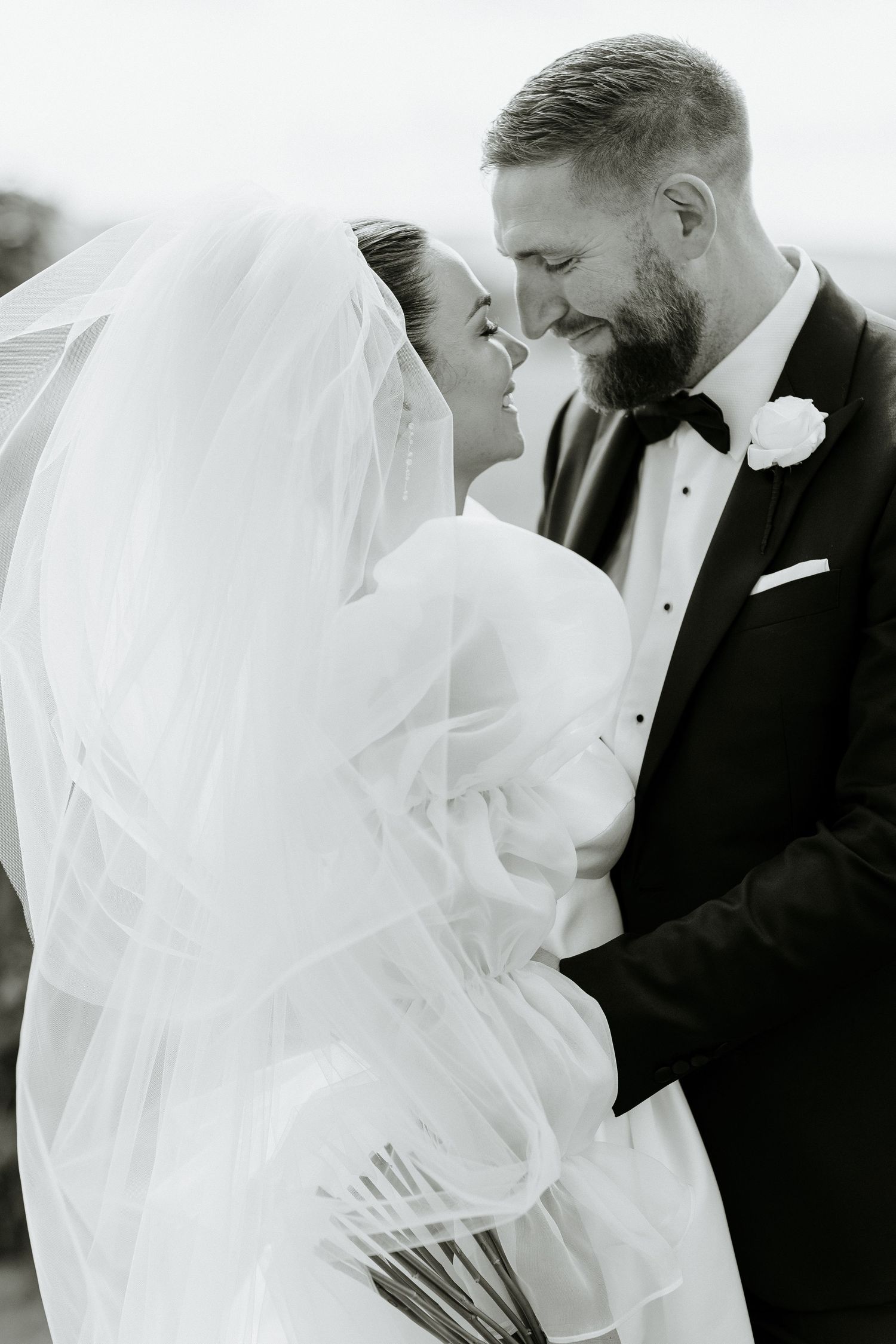Dramatic black and white wedding portrait with bride in ruffled ballgown.