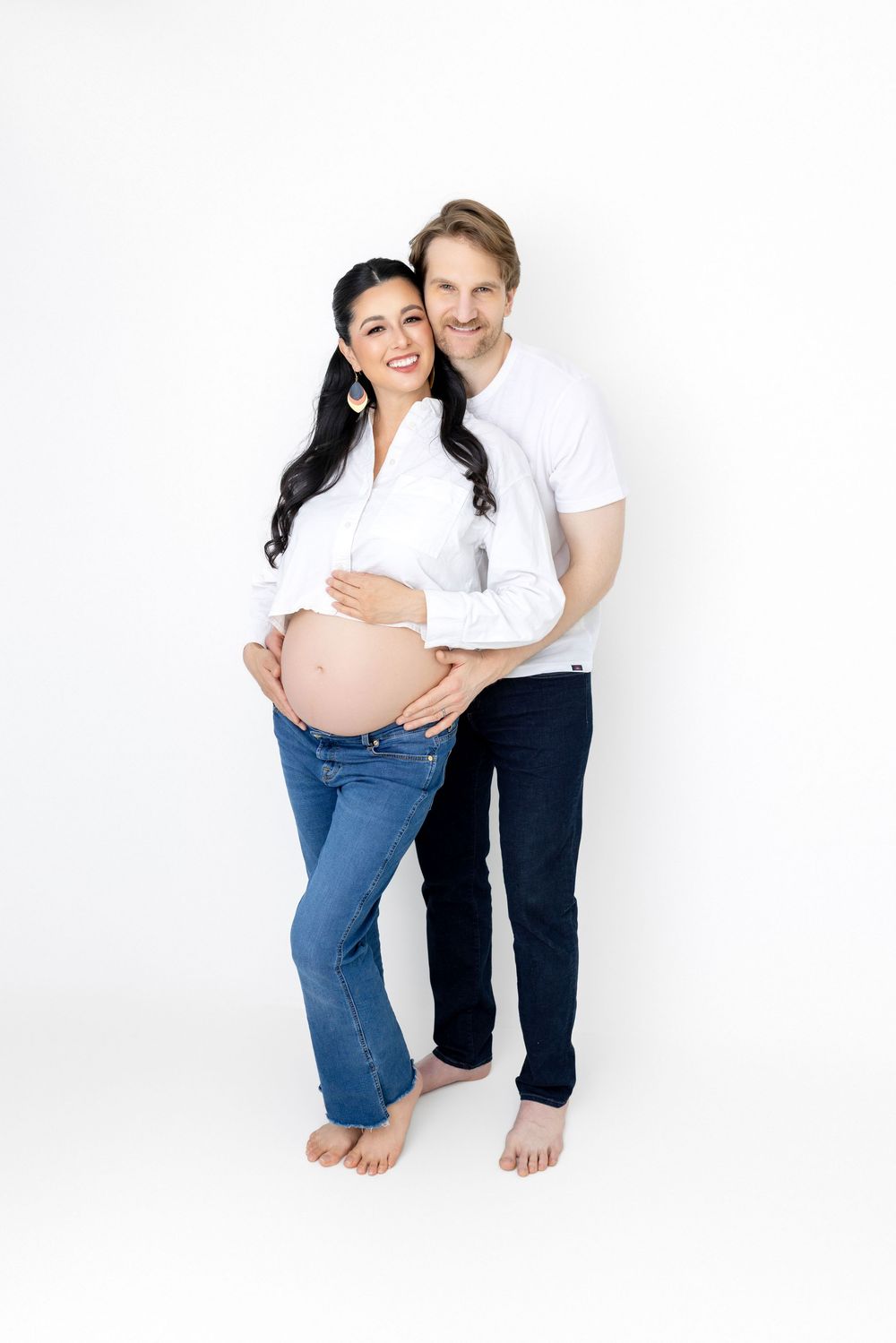 A maternity photo series showing four poses of a couple in white and blue against a white background.