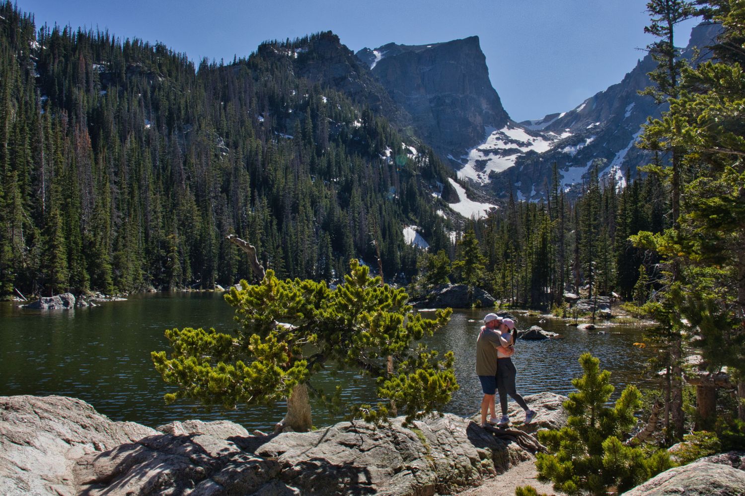 Couple embracing after his proposal to her at Dream Lake in the RMNP. Pixcapades | The Rocky Mountain Proposal Photographer