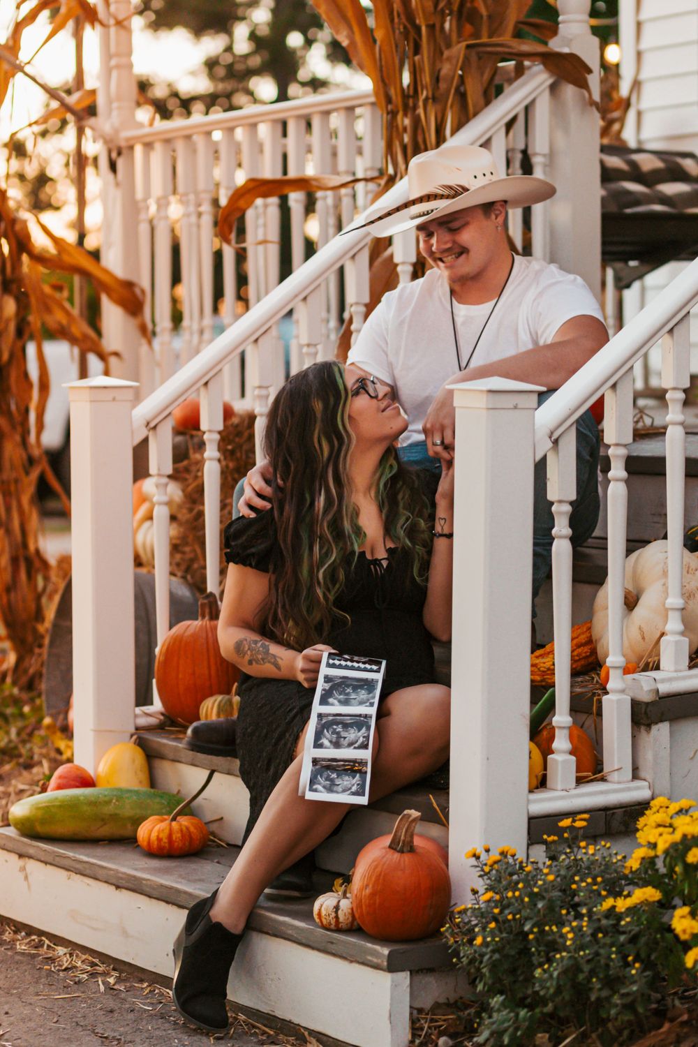 Pregnancy announcement at the pumpkin farm at sunset.