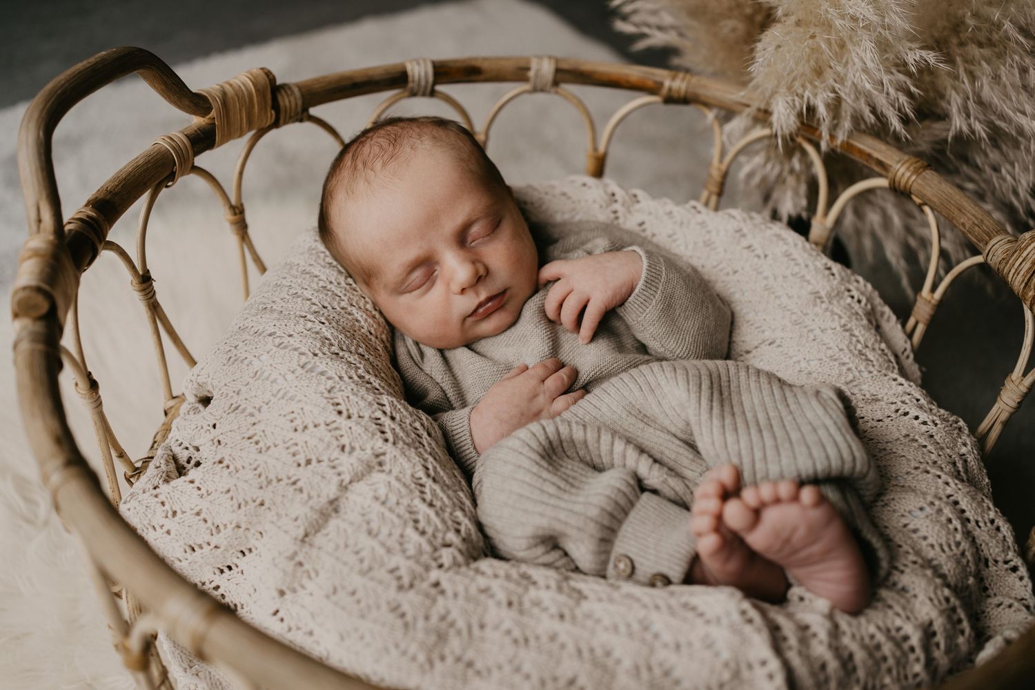 Schlafendes Neugeborenes in weichem Strick-Outfit bei einem Babyshooting im Boho-Stil in Mittelfranken