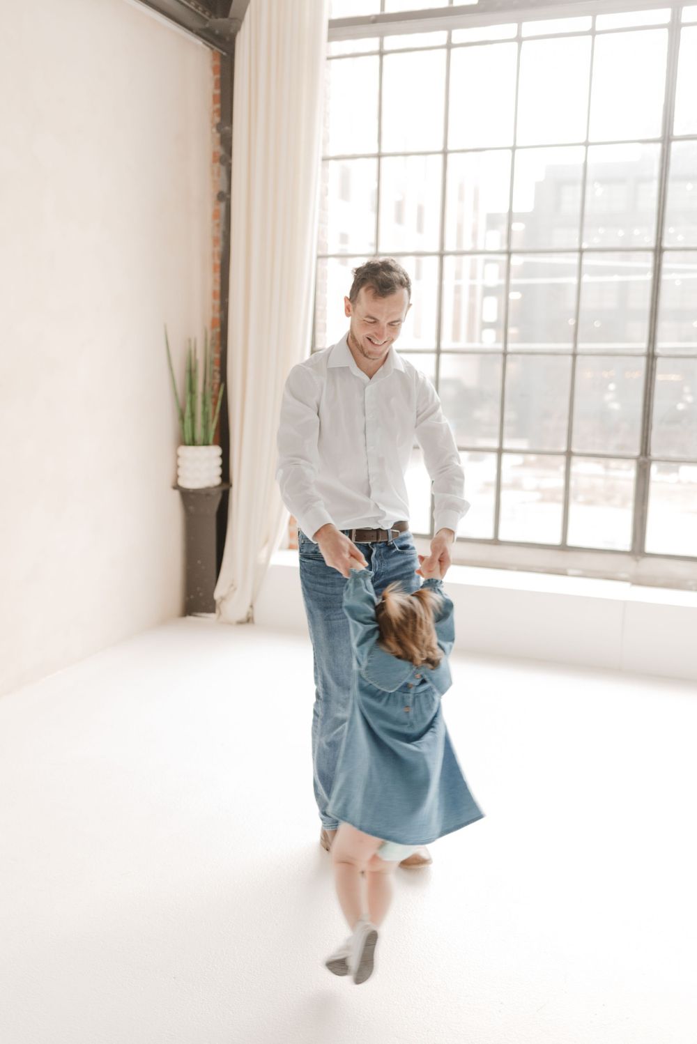 Father dancing with daughter during family photo session at Mint Room Studios in Toronto’s Preto Loft - joyful and candid family photography