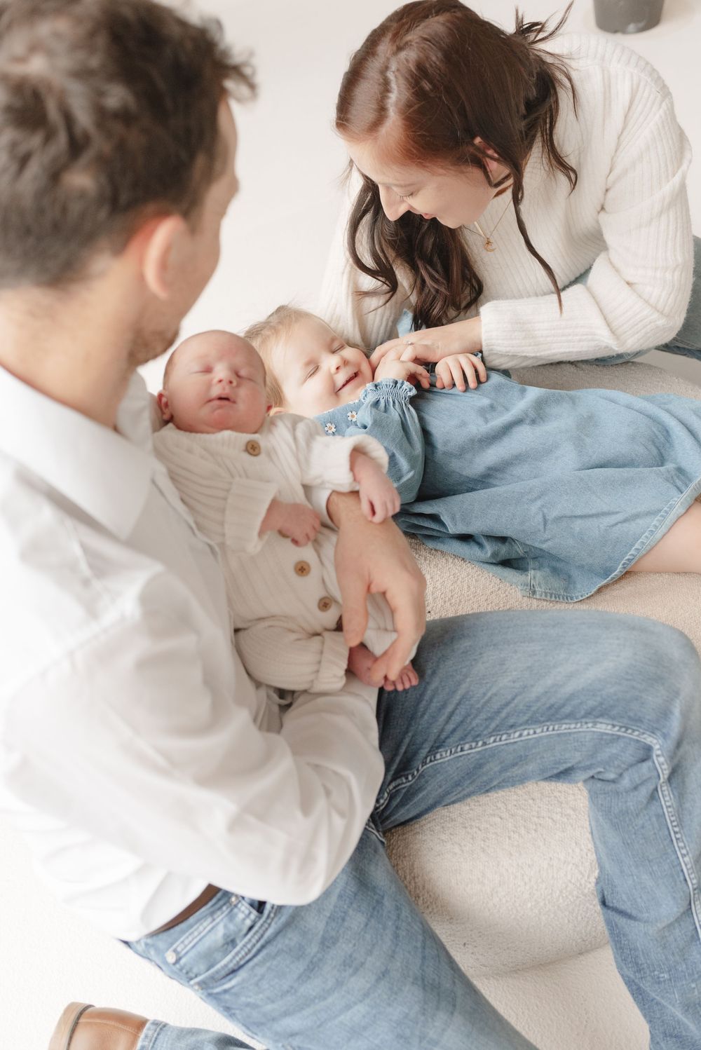 Candid portrait of family at mint room studio, playing with toddler and newborn baby. Captured by Toronto family photographer, Jess GC.