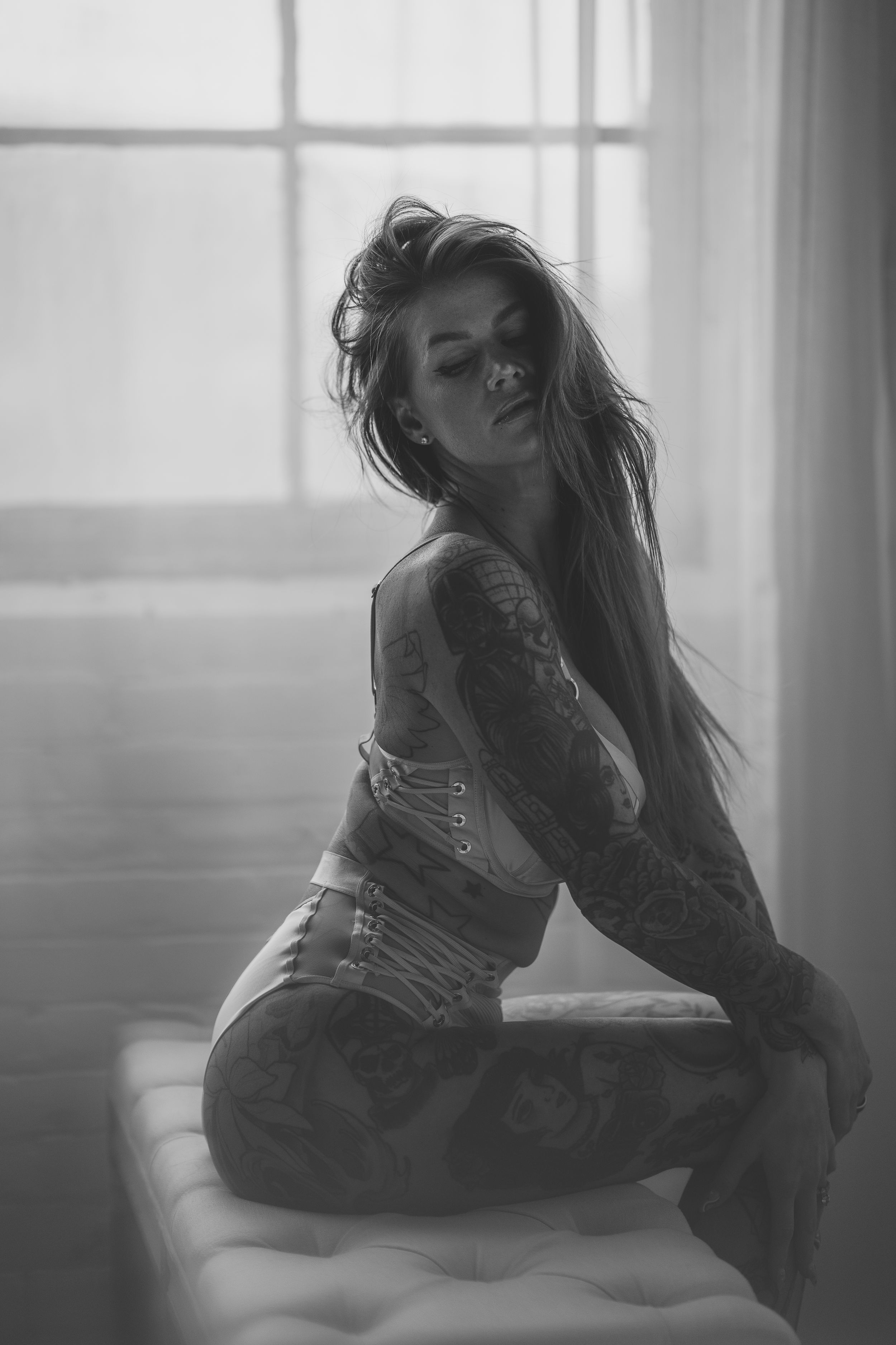 A black and white photo series shows a person in dramatic poses near a window with soft natural lighting.