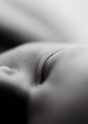 Close-up black and white macro photography of skin texture with soft shadows and delicate details.