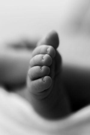 Close-up black and white macro photographs of tiny baby toes in sequence creating an artistic composition.