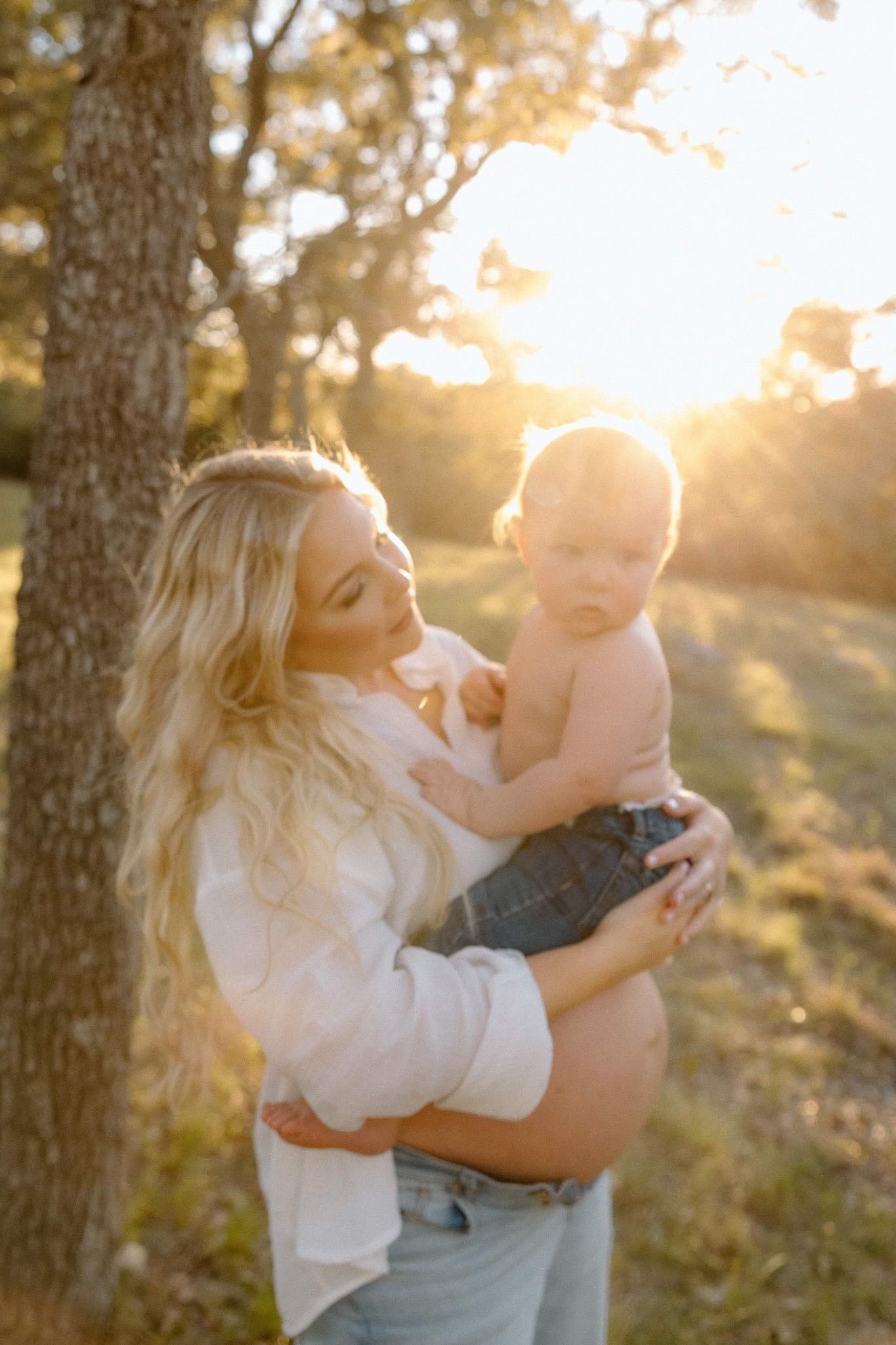 A tender moment between parent and baby captured in golden sunset light.