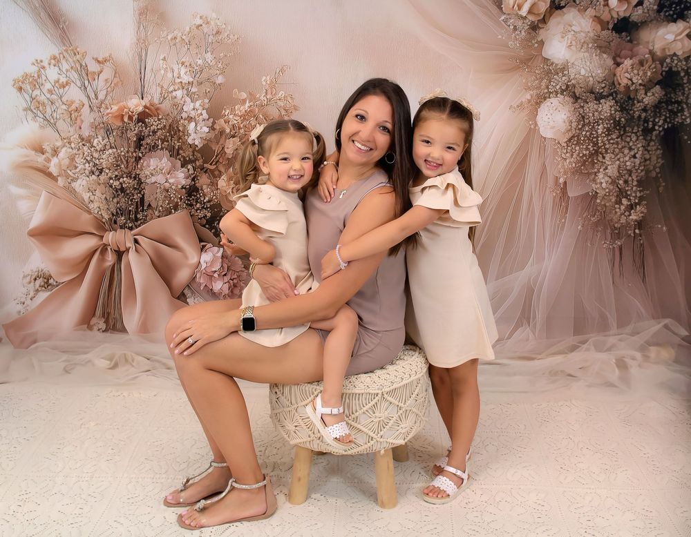 Studio family portrait session with romantic floral backdrop and soft lighting.
