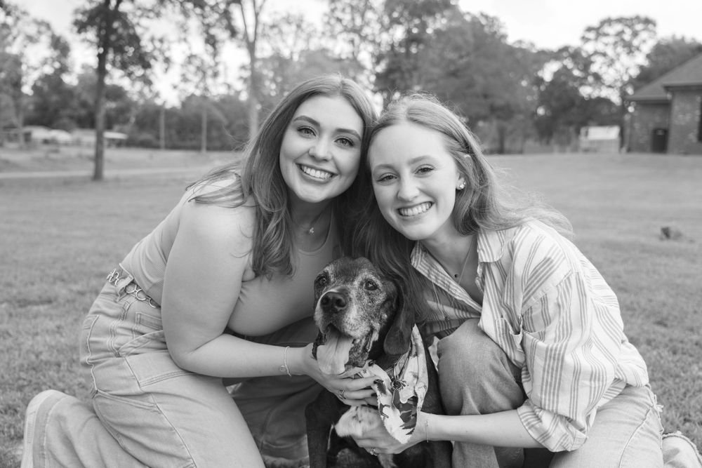 A joyful outdoor photo session with people lying on a blanket in a grassy field.