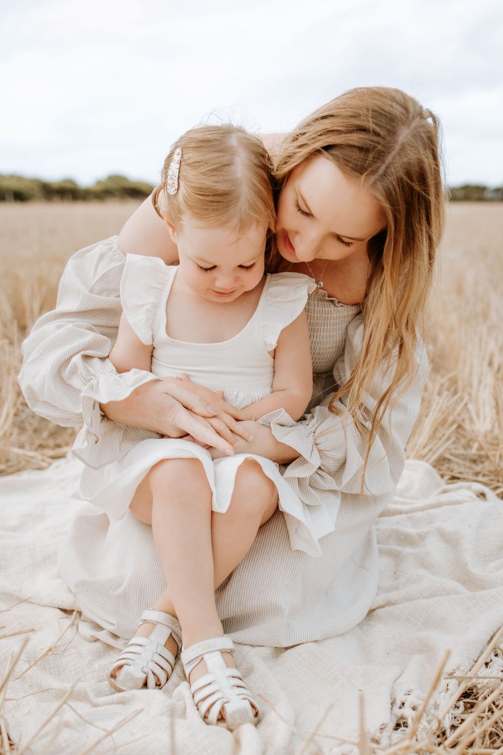 Adelaide family photographer - mother cuddling daughter in field