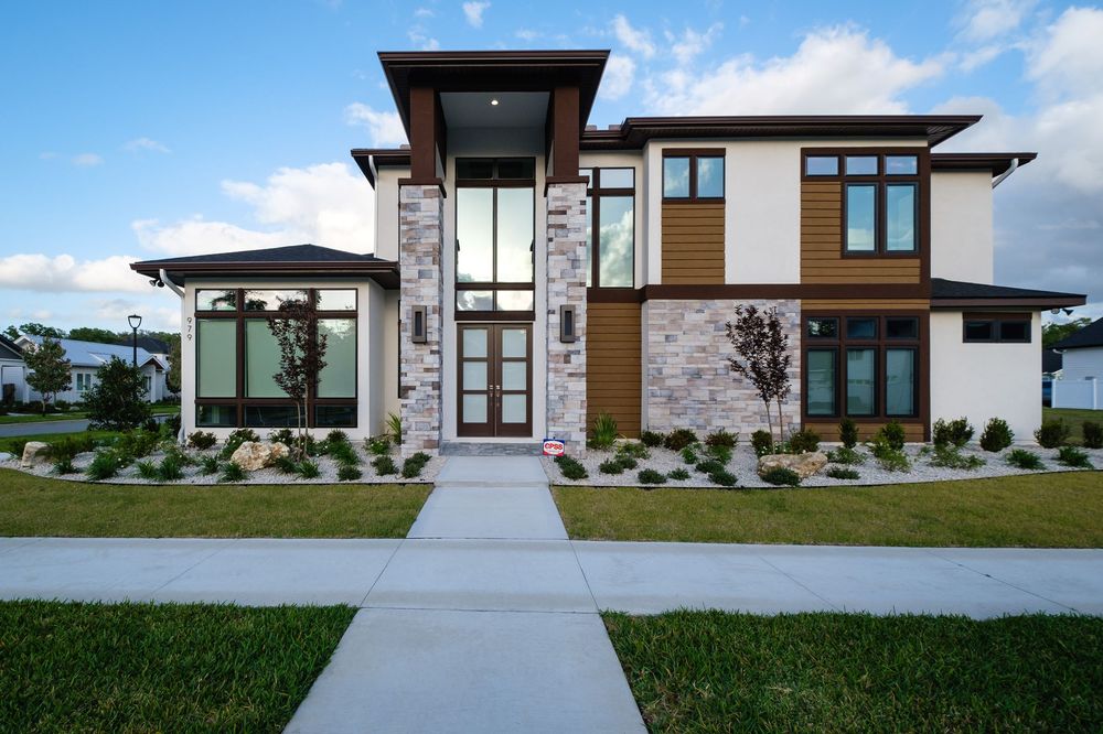 A large modern single family home with a green lawn and small shrubs located in the Town of Tioga.