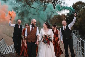 Wedding party poses together on stairs with teal and orange smoke bombs at the West Mill, Darley Abby, Derby.