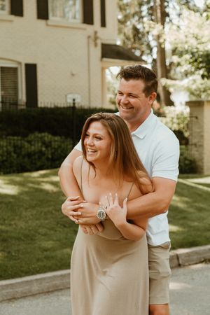Playful couple laughs and embraces during outdoor photo session.