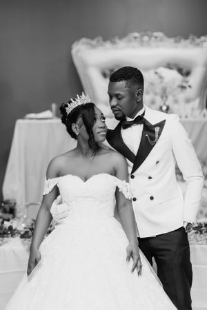 A romantic black and white portrait of a couple in wedding attire.