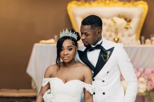 Elegant wedding couple in formal attire share an intimate moment against luxurious backdrop at reception.