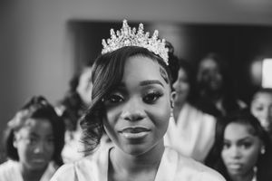 A bride wearing an elegant crystal crown in a black and white portrait.