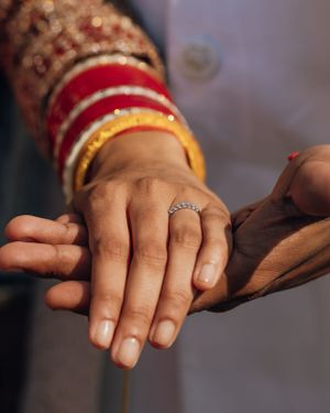 A close-up of hands showing traditional wedding bangles and an engagement ring.