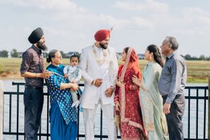 A group of family members gather outdoors for a traditional Sikh wedding celebration.