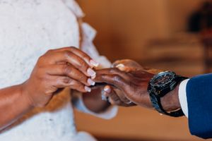 Close-up of hands exchanging wedding rings during a ceremony.