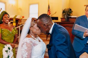 A joyous moment during a wedding ceremony in a church with red carpet.