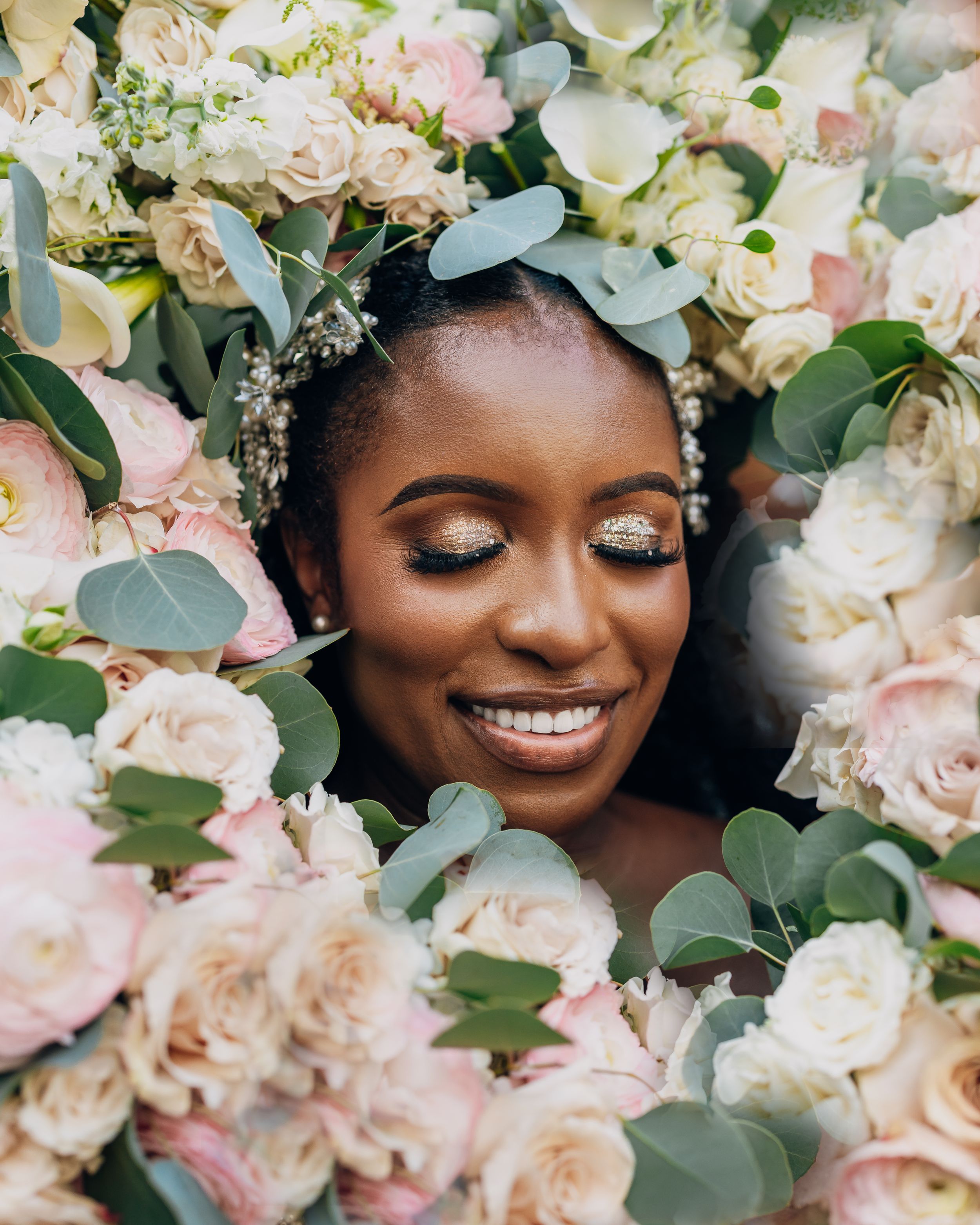 A series of close-up shots showing a joyful moment surrounded by delicate pink and white roses with eucalyptus foliage.