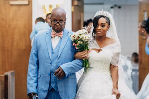 A couple walks arm in arm during a wedding ceremony procession.