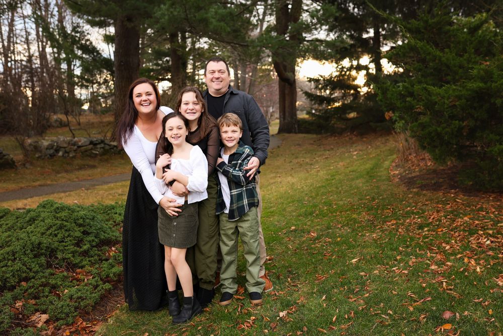 Family photographed hugging in a park in New Castle New Hampshire