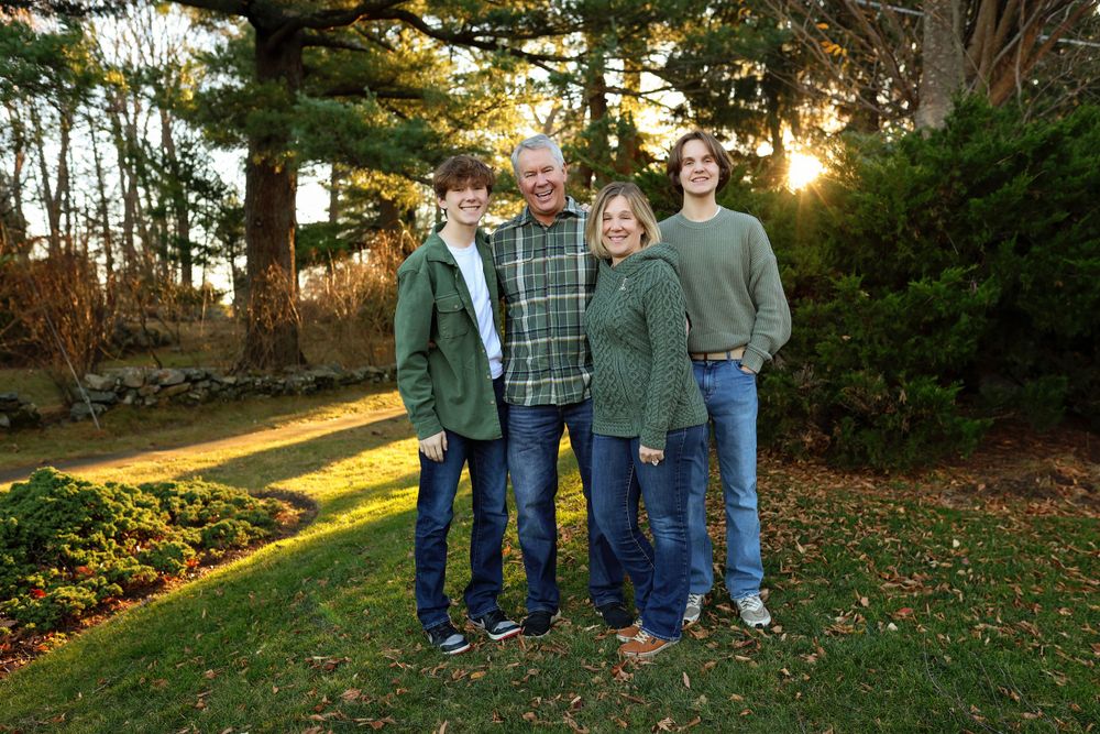 Family photographed standing wearing green in a park in New Castle New Hampshire