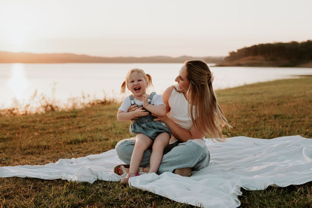 A tender sunset moment shared on a blanket by awoonga dam during golden hour.