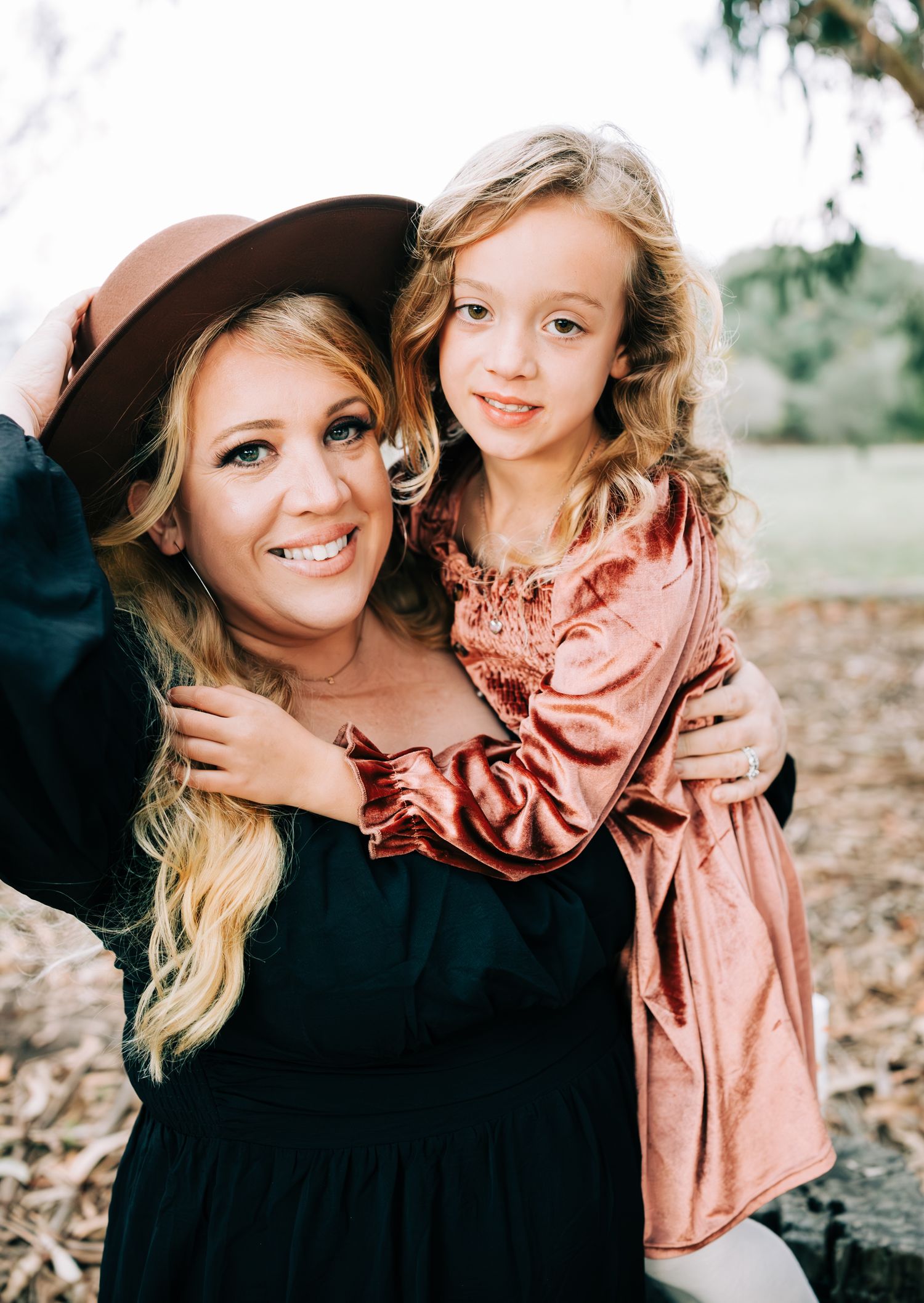 Mom in hat and black dress holding daughter in pink dress, Orcutt, CA