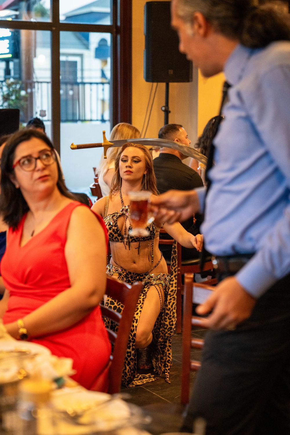 People gathered at a restaurant table enjoying entertainment and conversation.