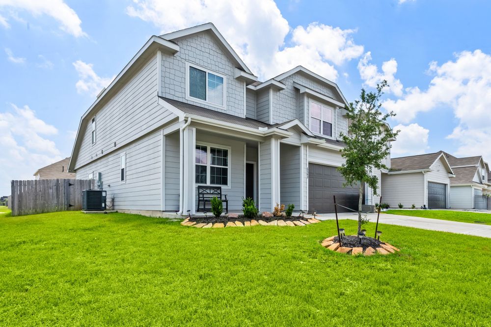Modern two-story white farmhouse style home with columned front porch and manicured lawn.