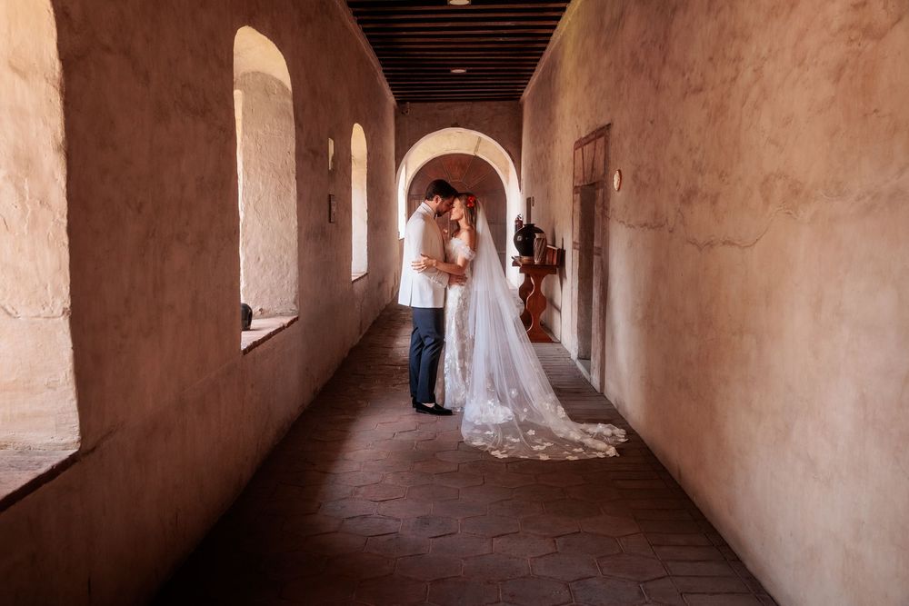 Long stone hallway with wooden ceiling and natural light streaming through windows.