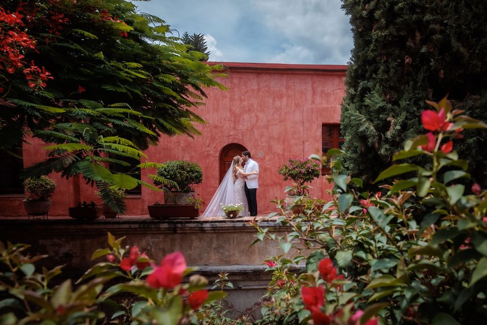 Historic Mexican colonial architecture with pink walls and stone pathways.