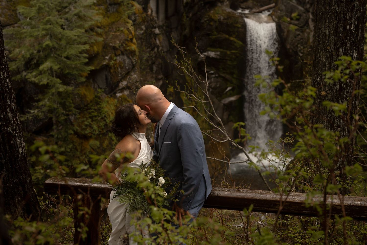 Silhouette figure with arms outstretched against a misty waterfront backdrop at sunset.