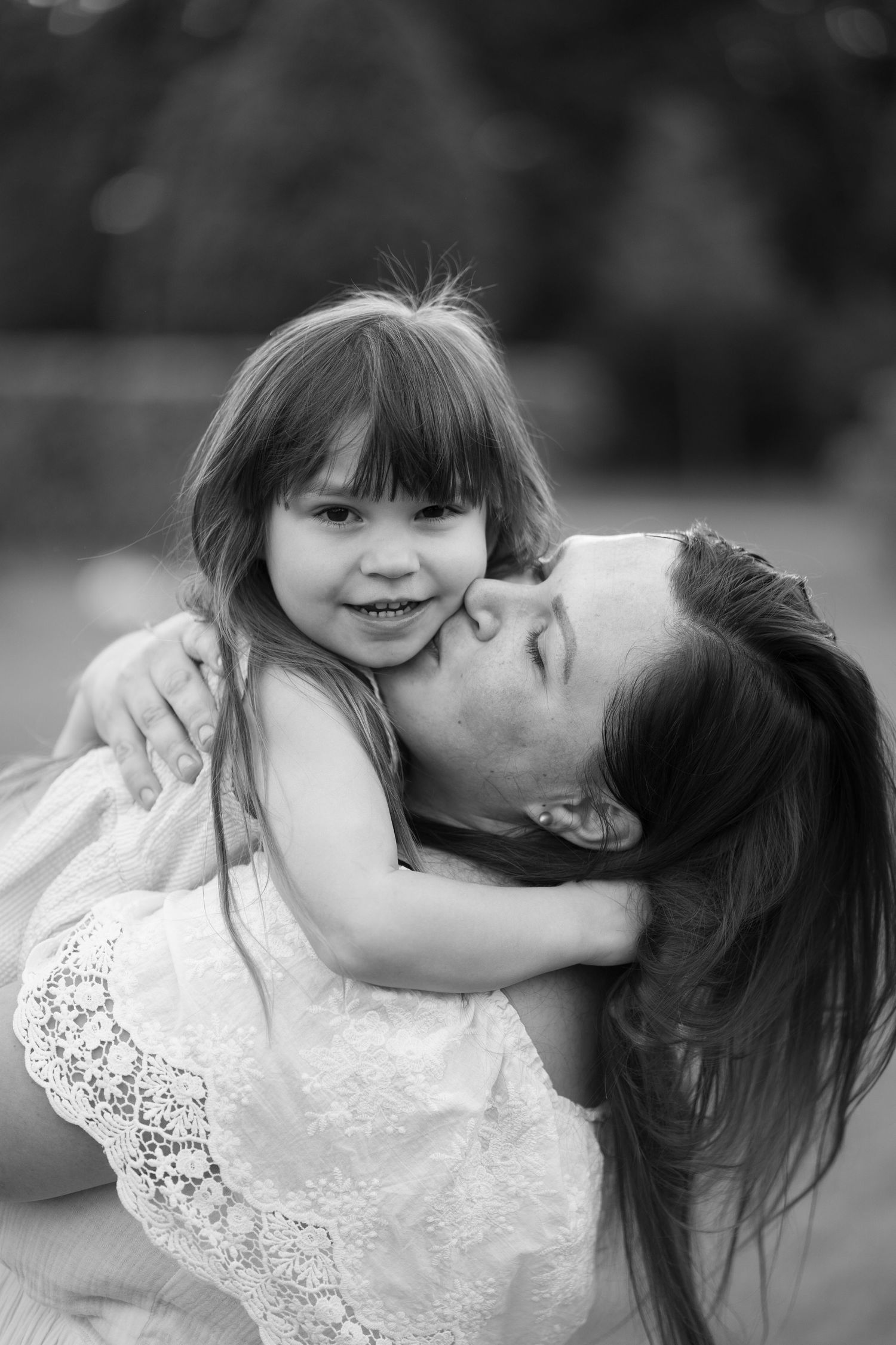 An intimate black and white portrait showing a tender moment of comfort and embrace.