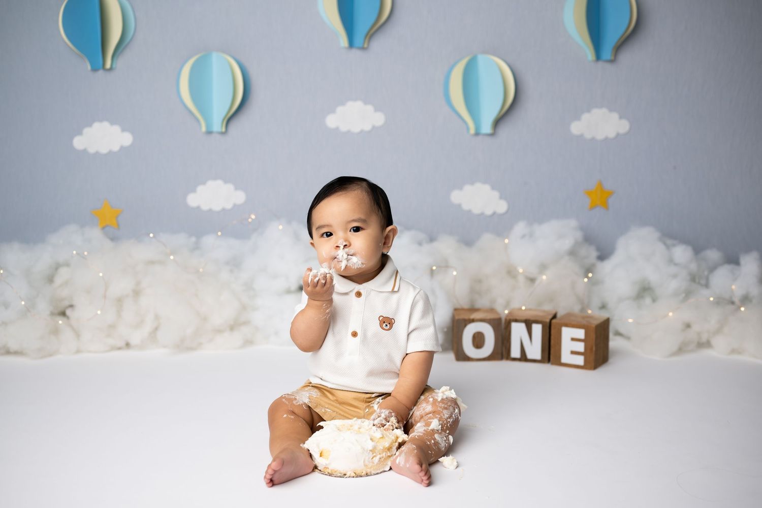 Cake smash preparation portrait with hot air balloon decor and 'ONE' blocks.