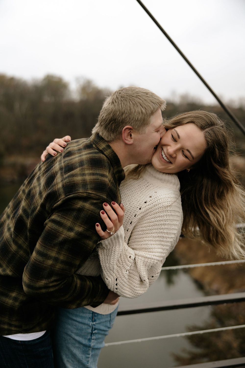 Intimate moment captured on a bridge during an outdoor photo session.