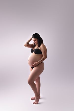 Artistic maternity portraits against a neutral backdrop showcasing the beauty of pregnancy.