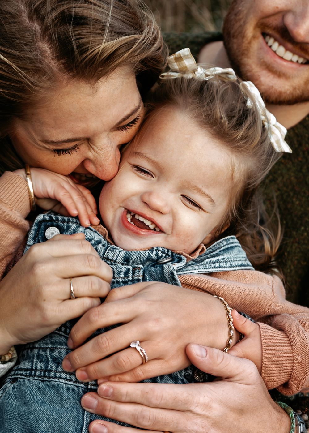 A series of close-up photos showing hands embracing a child in denim, capturing tender moments of affection and laughter.