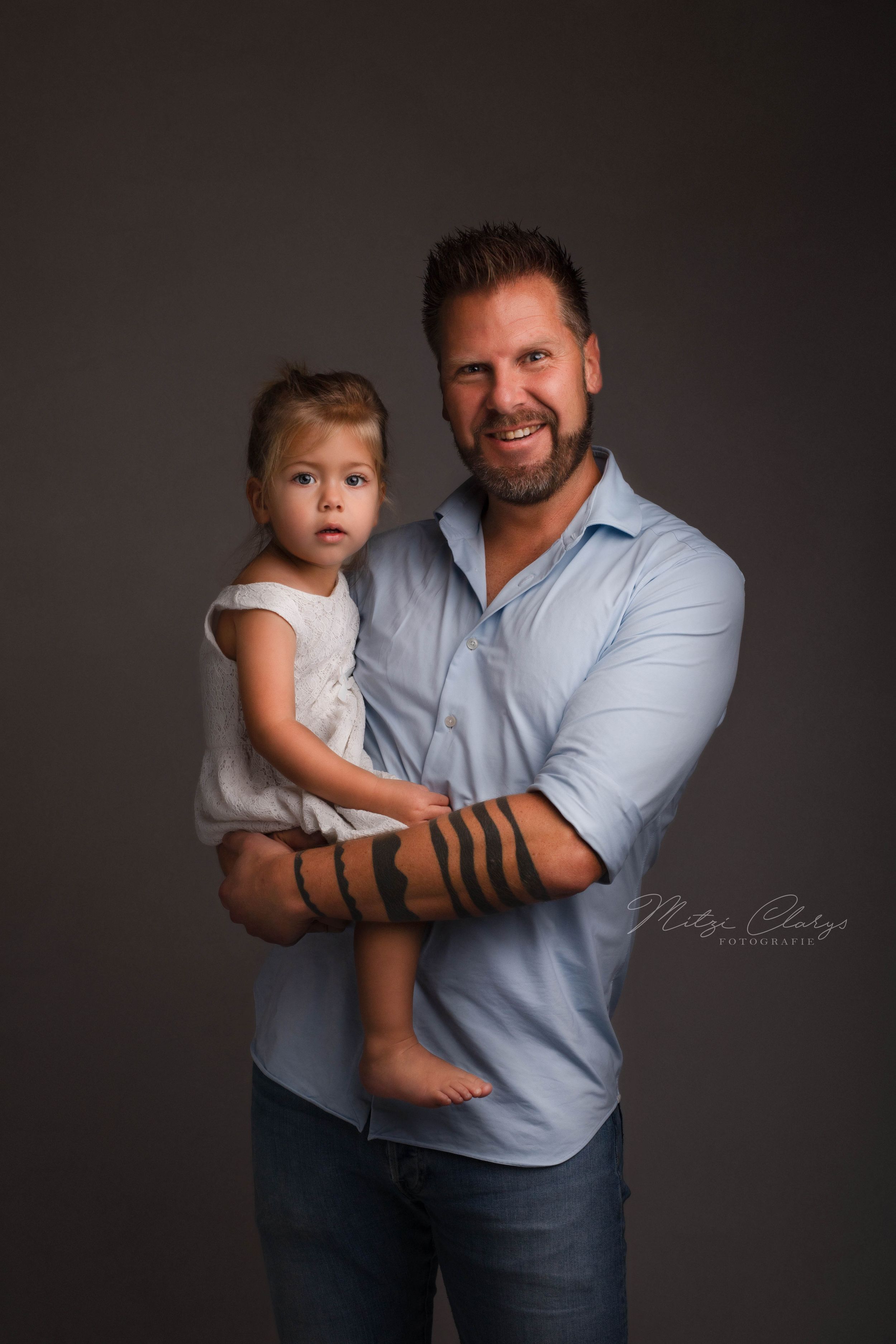Trotse vader met dochtertje op zijn arm tijdens fotosessie in Zeeland