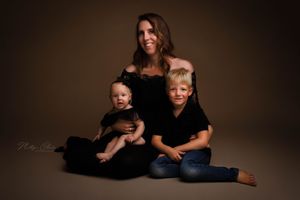 Moeder met kindjes in zwarte kleding tijdens mommy & mini fotoshoot in studio