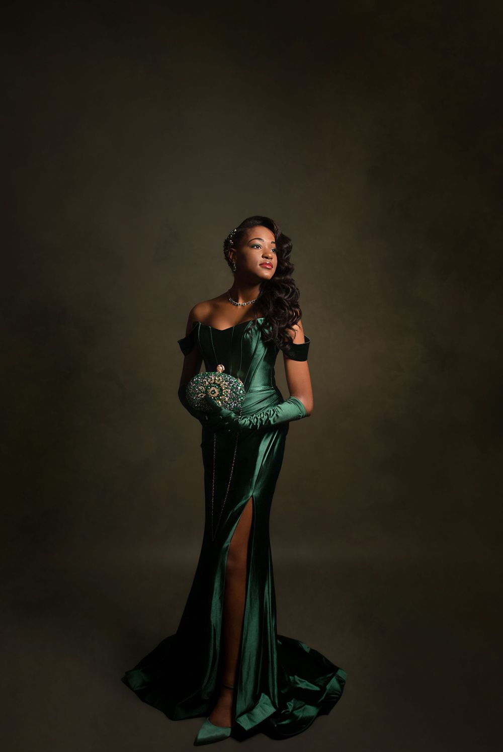 Dramatic fashion portrait series in emerald velvet gown against dark background.