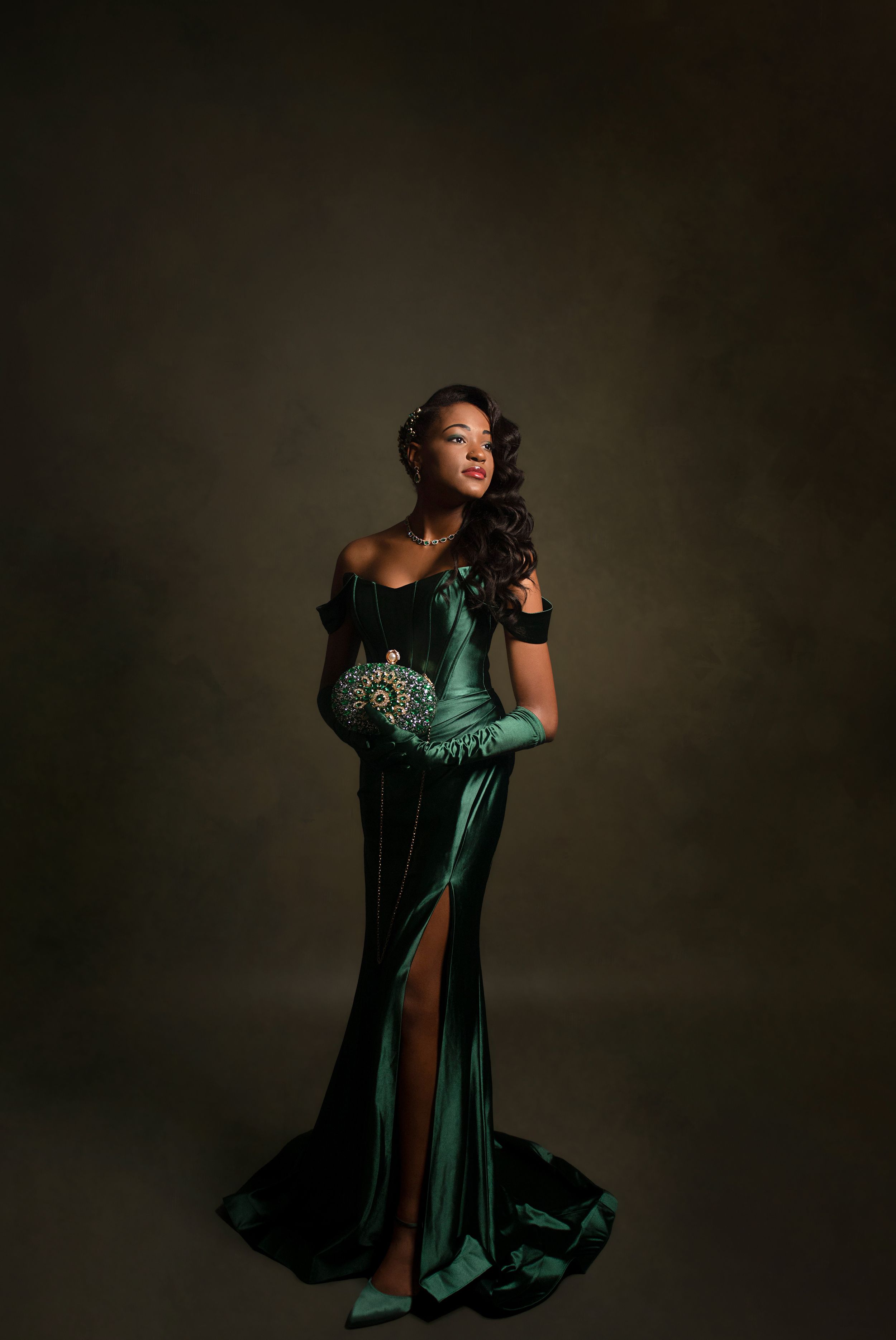 Dramatic fashion portrait series in emerald velvet gown against dark background.
