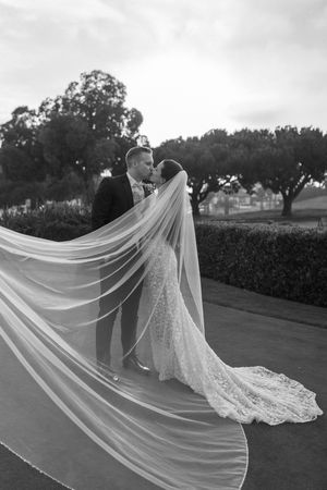 North Carolina wedding photographer capturing a romantic and dramatic kiss between the couple under a flowing veil.