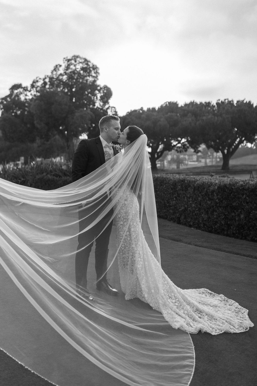 North Carolina wedding photographer capturing a romantic and dramatic kiss between the couple under a flowing veil.