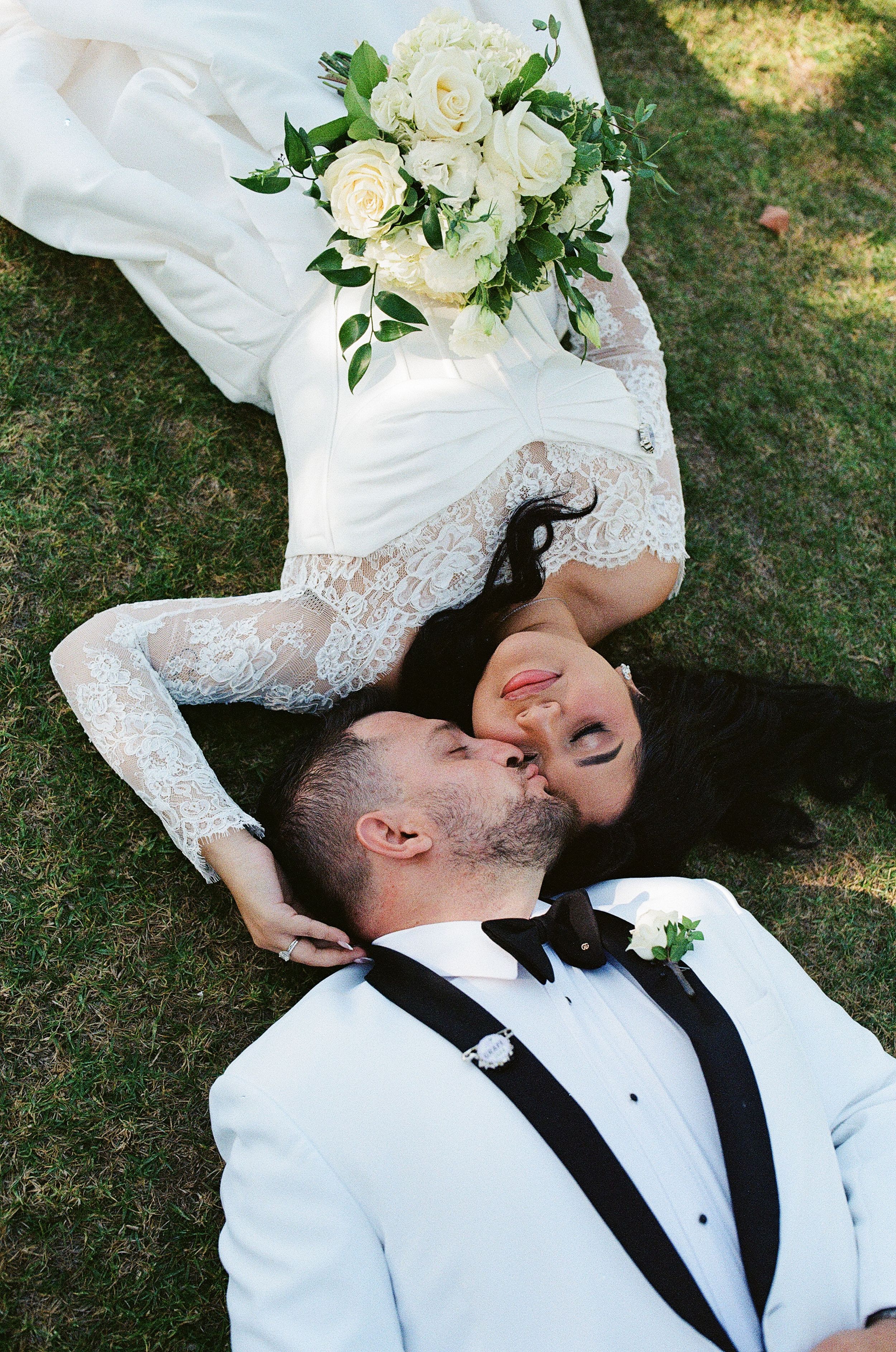 Casual film photo of a couple laying on the grass together