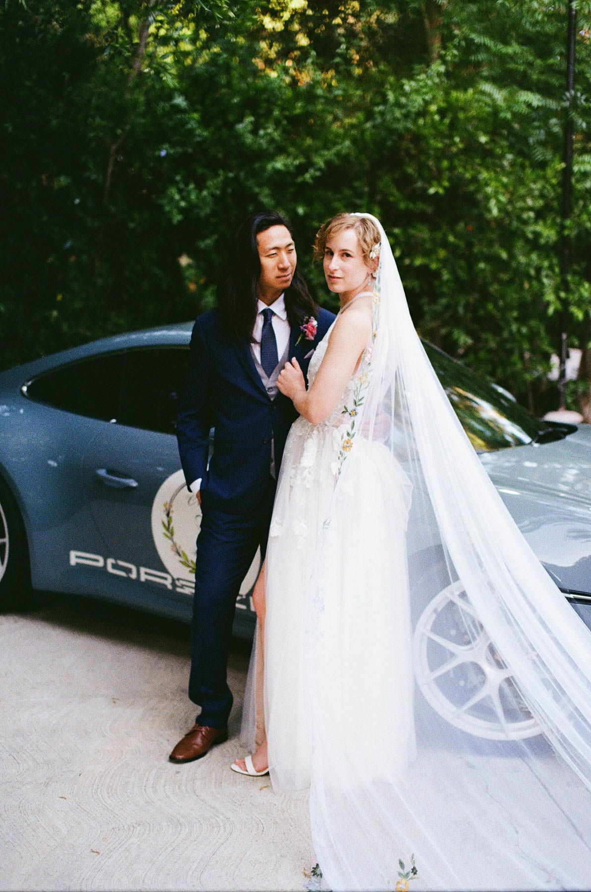 Documentary-style film wedding photography on 35mm film in North Carolina wedding venue showcasing couple with Porsche Car