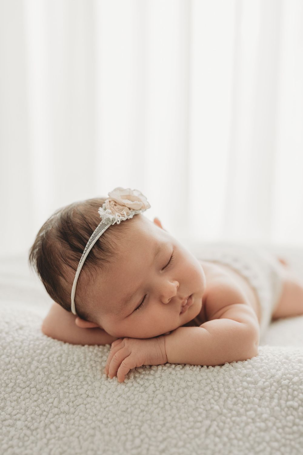 Baby girl sleeping on textured white blanket during newborn studio session in Etobicoke