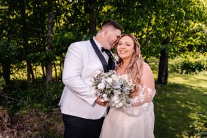 An intimate wedding portrait showcasing tender moments against a verdant garden backdrop.